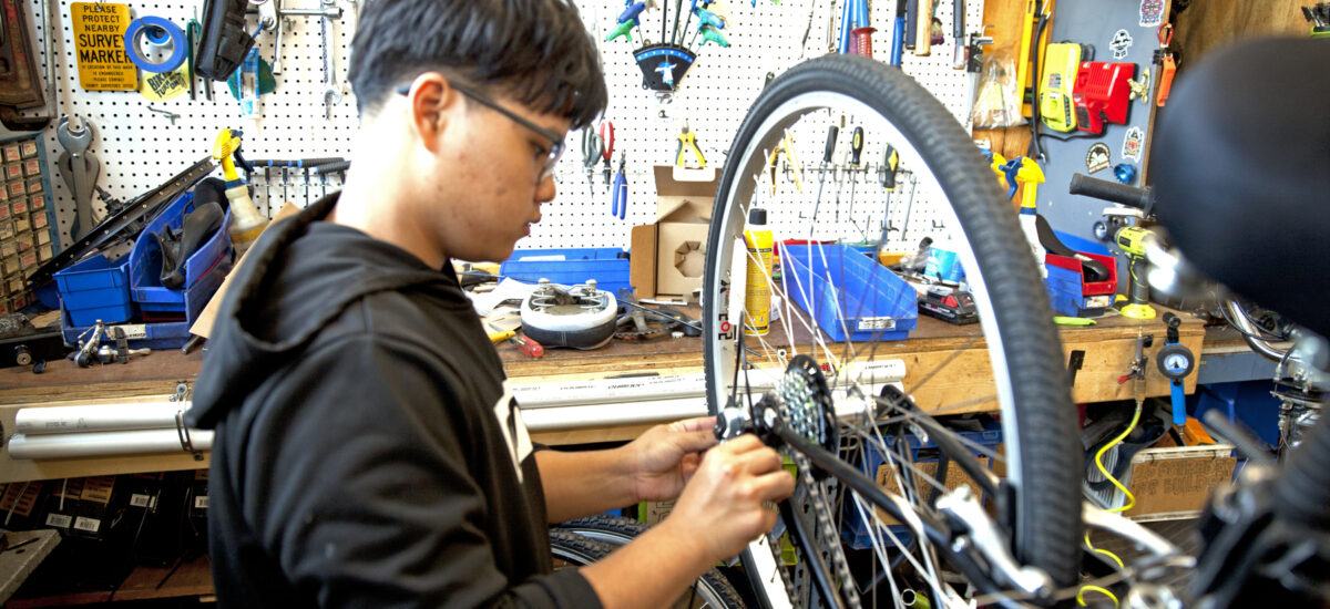 Youth apprentice working on bike