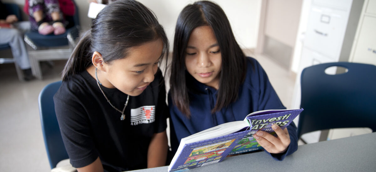 Youth and tutor reading together