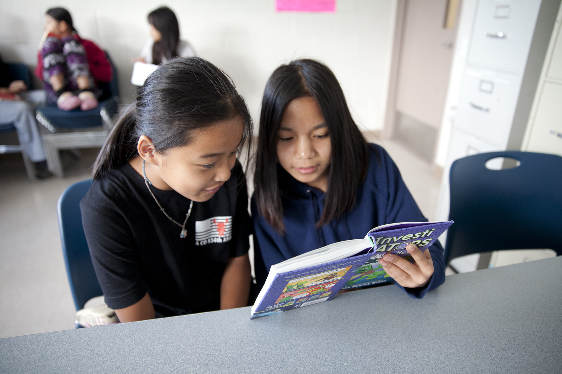 Youth and tutor reading together 