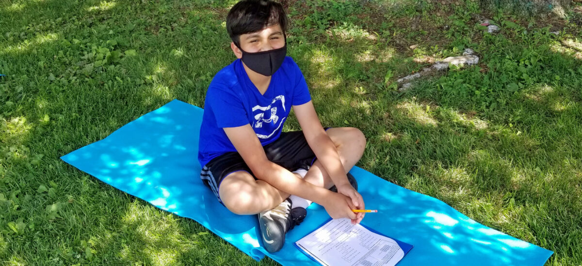 Student doing learning outside, socially-distanced